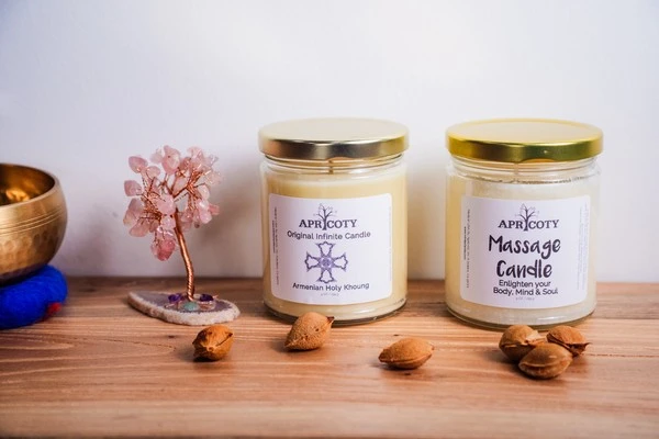 Apricoty candles in glass jars displayed with dried botanicals