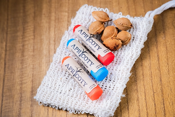 Apricoty pocket-size aromatherapy inhaler tubes displayed on knit fabric
