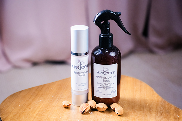 Apricoty apricot kernel oil and massage oil bottles on a wooden surface